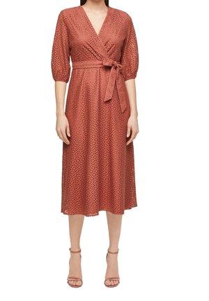 Rdzawoczerwona sukienka midi z tkaniny ażurowej, w stylu kopertowym, z trójćwiartkowymi bufkami na rękawach, przewiązana paskiem w talii, noszona z dopasowanymi szpilkami z paskiem wokół kostki.
