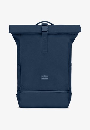 Mochila navy de roll-top fabricada con tela texturizada, con un cierre de correa resistente, presenta un parche con el logo en el frente y bolsillos laterales.