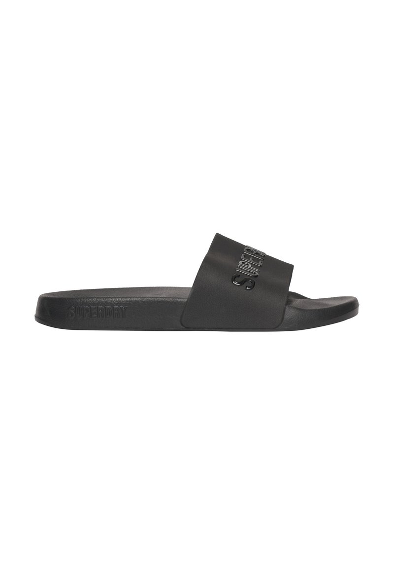 Zwarte slide sandaal met een matte afwerking, voorzien van een brede band en een gegraveerd "SUPERDRY" logo. Flexibele zool met een gestructureerd oppervlak.
