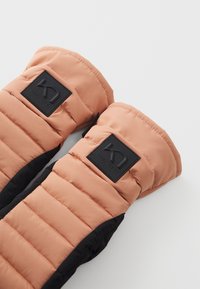 Ενισχυμένα γάντια σε κοραλλί και μαύρο χρώμα, με επενδυμένη υφή και έντονη μαύρη ετικέτα λογότυπου στην περιοχή του καρπού.