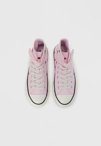 Ροζ ψηλά αθλητικά παπούτσια από καμβά με κόκκινα σχέδια καρδιάς, γκρι κο ρδόνια και λαστιχένιο κάλυμμα δακτύλων. Διαθέτουν μαύρη σόλα και κεντημένο λογότυπο.