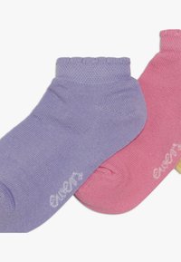 Et par ankelstrømper i lavendel og pink bomull, med en ribbet mansjett og en kontrasterende hvit logo på siden av hver sokk.