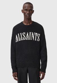 Juodas megztinis su ilgu rankovėmis ir "ALLSAINTS" logotipu balta spalva, turintis apvalią iškirptę ir raukinėtas rankoves bei apačią. Minkšta tekstūra su plačiu siluetu.