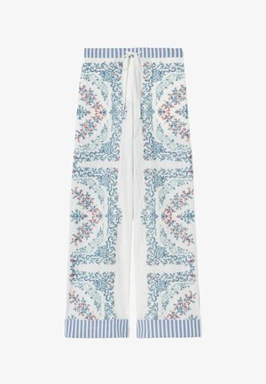 Pantaloni bianchi a gamba larga con ricamo intricato blu e rosso e fascia in vita e polsini a righe verticali blu, con chiusura frontale con coulisse.
