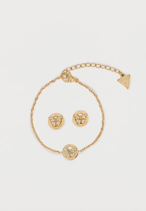 Gold bracelet and matching stud earrings with butterfly designs adorned with small clear crystals on a white background.