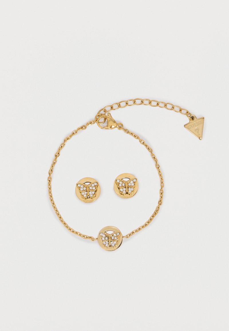 Χρυσό βραχιόλι και ταίριαστα καρφωτά σκουλαρίκια με σχέδια πεταλούδας διακοσμημένα με μικρούς διάφανους κρυστάλλους σε λευκό φόντο.