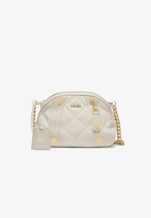 Sac à main en crème matelassé avec des détails en métal doré, une chaîne en bandoulière, une étiquette de marque et des embellissements ronds. Design compact et arrondi.