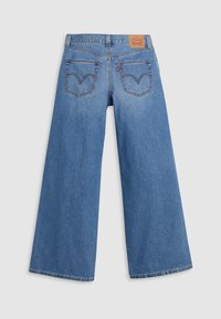 Pantalones vaqueros de pierna ancha en denim azul claro, con una cintura alta, bolsillos traseros clásicos con detalles de costura y una etiqueta de cuero en la cinturilla.