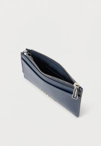 Laivastonsininen nahkalompakko, jossa on teksturoitu pinta, vetoketjulla suljettava ja hopeanväriset metalliosat. Yksi ulkoinen vetoketjullinen tasku. Kompakti muotoilu.