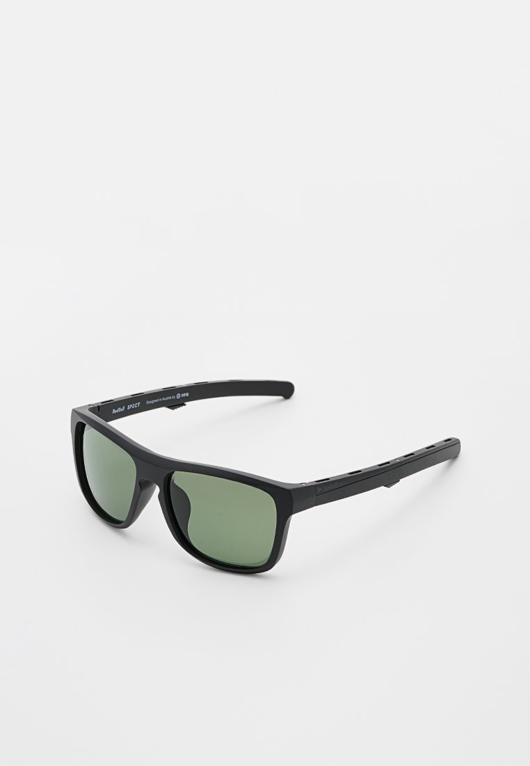 Gafas de sol negras con lentes verdes, de forma rectangular y con brazos texturizados que presentan acentos recortados. Diseño de marco de plástico ligero.
