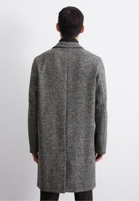 Grijze visgraatjas met een gestructureerde kraag, lange mouwen en een knie-lange snit, met een gladde textuur en een op maat gemaakte pasvorm.