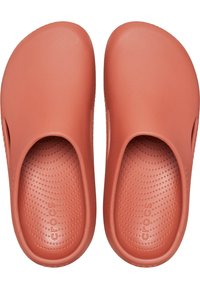 Terracotta clogs made of lightweight foam. Rounded shape with open backs, textured insoles featuring small dots, and drainage holes on sides.