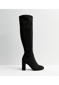 Botas negras de ante sobre la rodilla, con un tronco ancho, tacón de bloque, punta redondeada y un diseño sin costuras sin hardware visible.