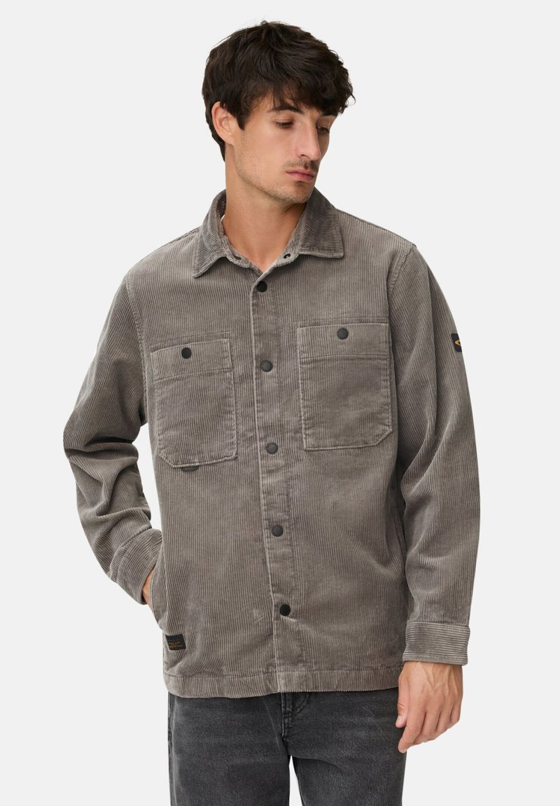 Ribjakke i grå med krave, to forlommer, sorte knapper og lange ærmer med knappede manchetter.