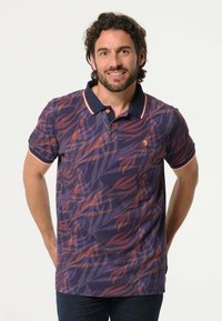 Polo shirt in donkerpaars met een gedurfde rode en oranje bladerenpatroon. Bevat een marineblauwe kraag en een twee-knopen-sluiting. Gemaakt van zachte katoenen stof.