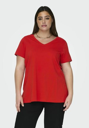 T-shirt rouge à manches courtes en V, à la coupe décontractée, fabriqué à partir d'un tissu doux avec une texture lisse. Porté avec un pantalon cargo noir.