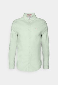 Camicia a maniche lunghe verde chiaro con colletto a bottoni, dotata di un piccolo logo ricamato e bottoni crema. Tessuto testurizzato.