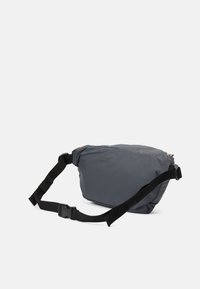 Grå, blød nylon skuldertaske med justerbar sort strop, der har en lynlåslukning og et minimalistisk design.