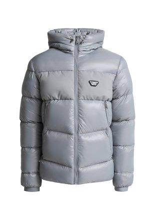 Homme en doudoune grise et pantalon noir se tient devant un bâtiment noir, touchant son front alors qu'une légère neige tombe autour de lui.