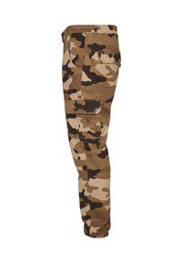 Men’s cargo pants in brown, beige, and black camouflage with multiple flap pockets and elasticized cuffs, shown from the side.
