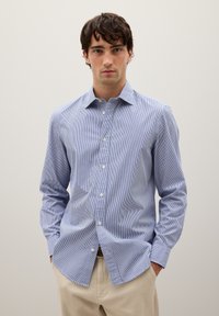 Camisa de botones a rayas azul y blanca, con mangas largas, cuello clásico y dobladillo recto, hecha de una tela ligera.