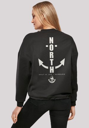 Schwarzer Sweatshirt mit weißem "NORTH"-Text, Pfeilen und dem "Knut & Jan Hamburg"-Logo auf der Rückseite. Weicher Stoff, lockere Passform, gerippte Bündchen.