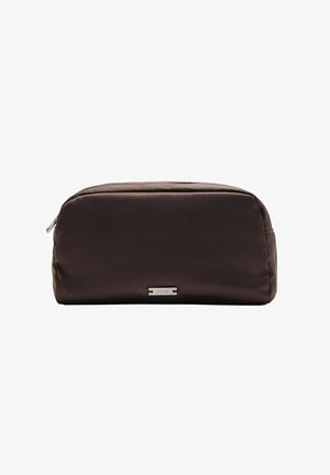 Trousse de toilette rectangulaire marron foncé avec fermeture éclair et petite étiquette de marque argentée à l'avant sur fond blanc.