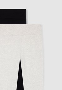 Czarne i jasnoszare legginsy ułożone poziomo; czarne na górze o gładkiej fakturze, a jasnoszare z miękkim, melanżowym wzorem.