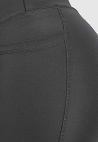 Leggings neri elasticizzati con una superficie liscia, design aderente e dettagli di cucitura visibili lungo le cuciture. Nessuna tasca visibile.