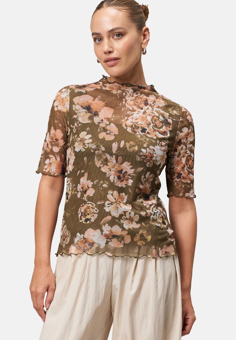 Floral sheer top in olive green with large pink and cream flowers. Short sleeves and scalloped hem create a soft, flowing silhouette.