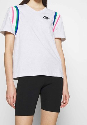 Szara koszulka Nike z dekoltem w serek, z różowymi, zielonymi i niebieskimi paskami na ramionach; noszona z czarnymi szortami rowerowymi.