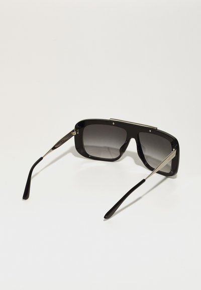 Black oversized sunglasses with gradient lenses, a bold square shape, silver accents on the bridge, and sleek black synthetic temples.