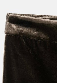 Zložená tmavo hnedá zamatová textília s jemnou štruktúrou a subtilným leskom, s čistými okrajmi a minimálnymi švovými detailmi.