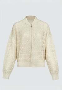 Veste bomber beige en dentelle avec fermeture éclair à l'avant, manches longues, poignets, ourlet et col côtelés, présentée sur un fond uni.