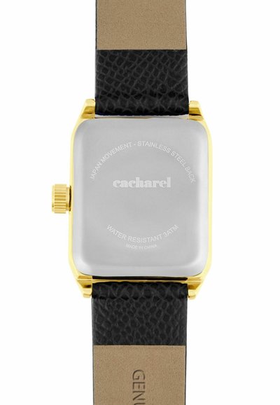 Vierkante achterkant van een gouden horloge met een zwarte, gestructureerde leren band en gegraveerde tekst met details over waterbestendigheid en Japanse uurwerk.