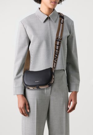 Borsa a spalla in pelle nera con un design curvo, dotata di una tracolla brandizzata in marrone e grigio molto evidente. Lo sfondo è neutro.