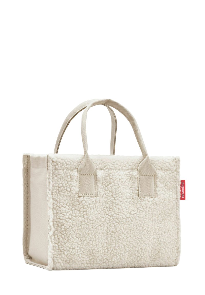 Borsa a tracolla in shearling bianco con dettagli in tessuto beige, due manici corti e un'etichetta rossa sul lato. Forma rettangolare, texture morbida.
