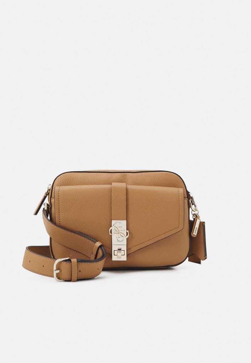 Bolso bandolera de cuero color marrón claro con superficie texturizada, solapa geométrica, herrajes plateados y correa ajustable. Cuenta con cierre de broche.