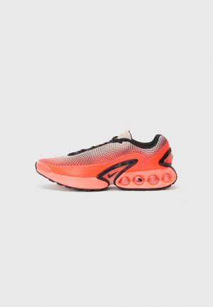 Athletic shoe with a mesh upper in gradient orange and black, featuring a thick sole with visible air cushioning pods in a coral hue.