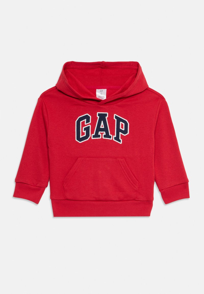Sweatshirt à capuche rouge avec une poche frontale, arborant le logo "GAP" en marine. Fabriqué en tissu doux avec une coupe décontractée et des poignets côtelés.