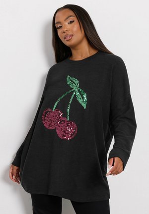 Czarna, oversize bluza z wzorem wisienek wykonanym z cekinów; zawiera dwie czerwone wisienki i zielone liście, tworząc teksturowany wygląd.