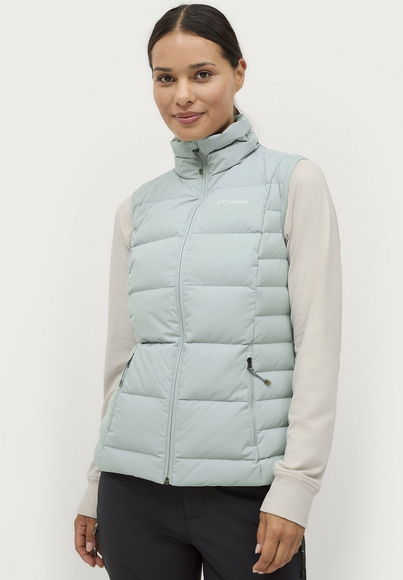 Gevoerde lichtblauwe vest met hoge kraag, ritssluiting aan de voorkant en twee zijzakken. Heeft een gewatteerd ontwerp en een subtiele logo op de borst.