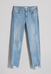 Jeans de un azul claro desgastados que presentan un ajuste slim, con detalles rasgados en las rodillas y dobladillos deshilachados. Fabricados en tela de mezclilla con un diseño clásico.