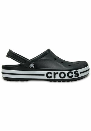 Zwarte Crocs klompen met een achterkantriem, voorzien van ventilatiegaten, een witte gestreepte zool en het "crocs" logo aan de zijkant.