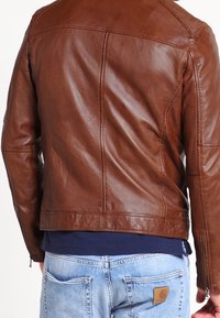 Brun läderjacka med en mjuk textur, figursydd design och subtila sömmar. Har en zipprad ärm och bakseam.