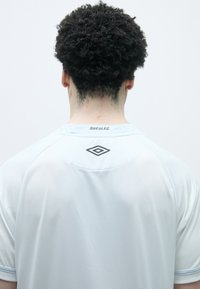 Gaiši zils sporta krekls ar acu struktūru, īsām piedurknēm un ribotu apkakli. Aizmugurē ir "Santos F.C." logo un melna akcenta detaļa.