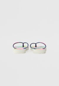 Chanclas con tirante de goma azul marino, suela blanca y estampado floral colorido en la plantilla con acentos en rosa y verde.