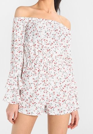 Combinaison blanche épaules dénudées avec imprimé floral rouge, dotée de manches cloche, d'une taille élastique et d'une coupe décontractée. Tissu doux et léger.
