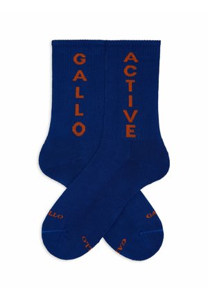 Calzini di cotone blu con testo verticale arancione "GALLO" e "ACTIVE". Tessuto liscio con polsino a coste e tallone rinforzato.