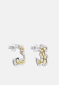 Pendientes de aro de metal en tonos plateado y dorado con un diseño ondulado, acabado brillante y respaldos de presión seguros.